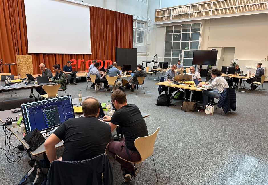 Gruppen von Engineers beim Hackathon in einer Halle Gruppen von Engineers beim Hackathon in einer Halle